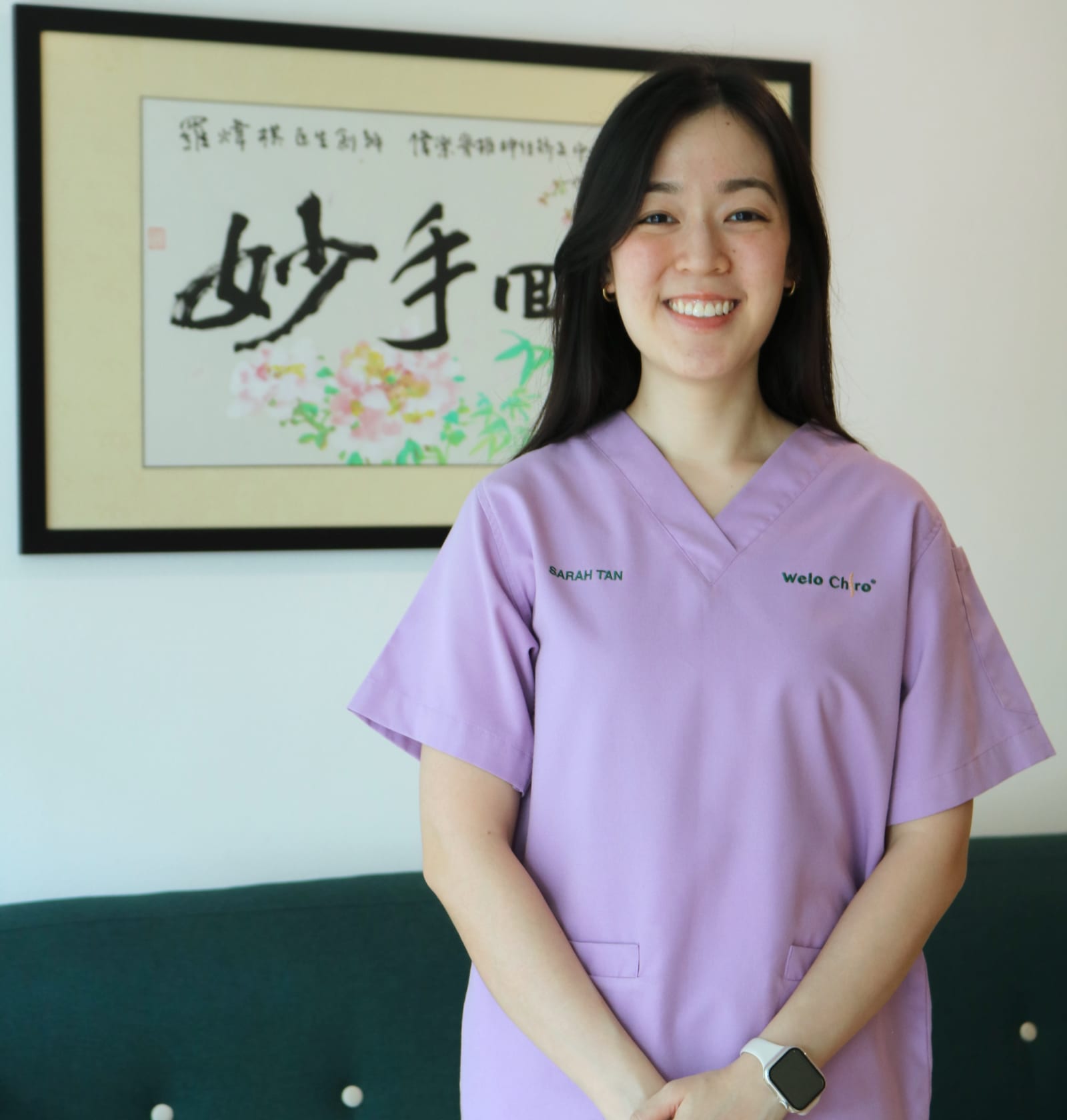Sarah Tan of Welo Chiro in front of the calligraphy at the Damansara Jaya branch